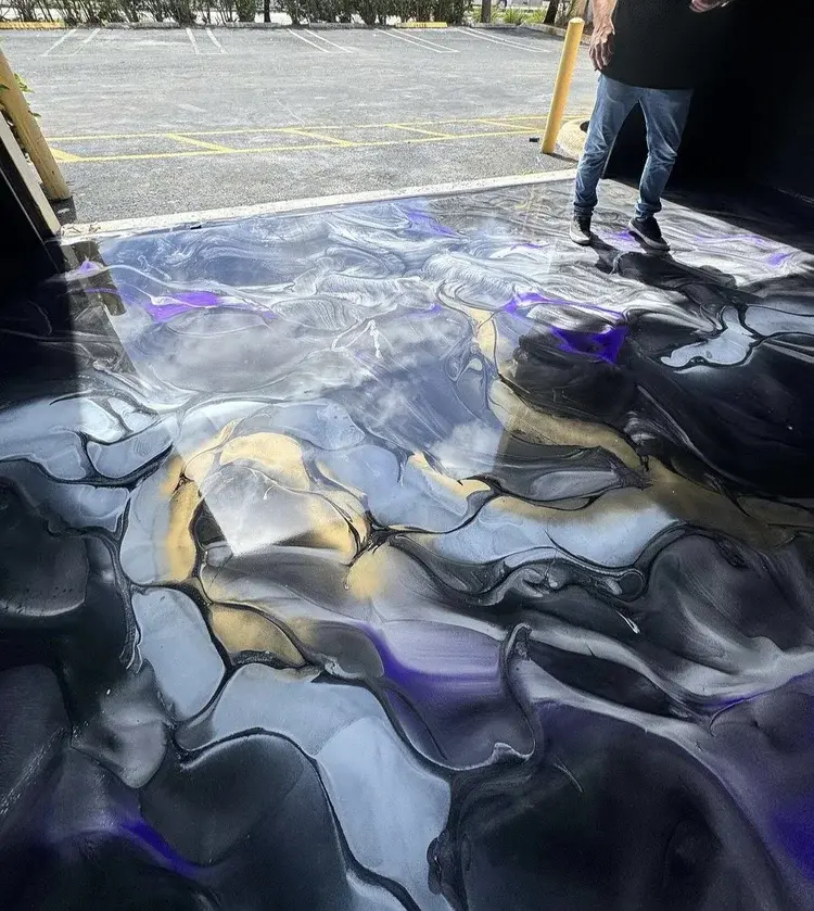 Metallic epoxy flooring with black, silver, gold, and purple finish